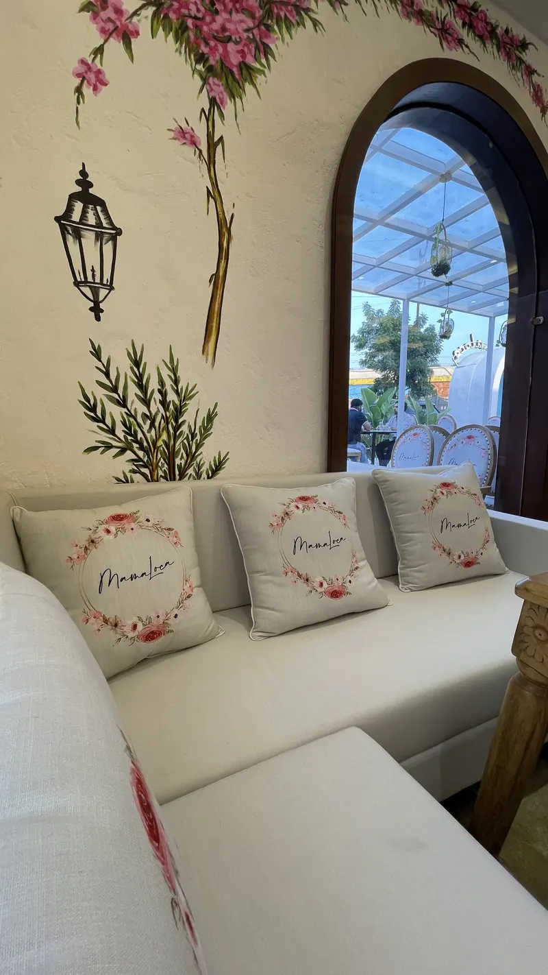 Mama Loca cushions on the banquette beside an arched window