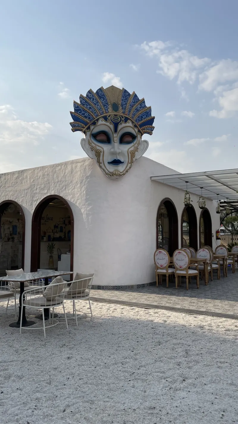 The mask on the white tower, seen from the gravel courtyard