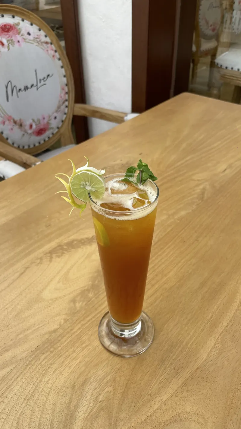 An amber highball with a lime wheel and mint