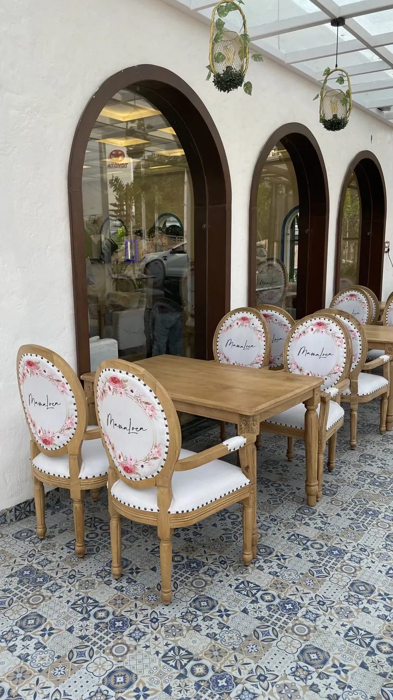 Pergola tables beside three tall arched windows, on blue patterned tile