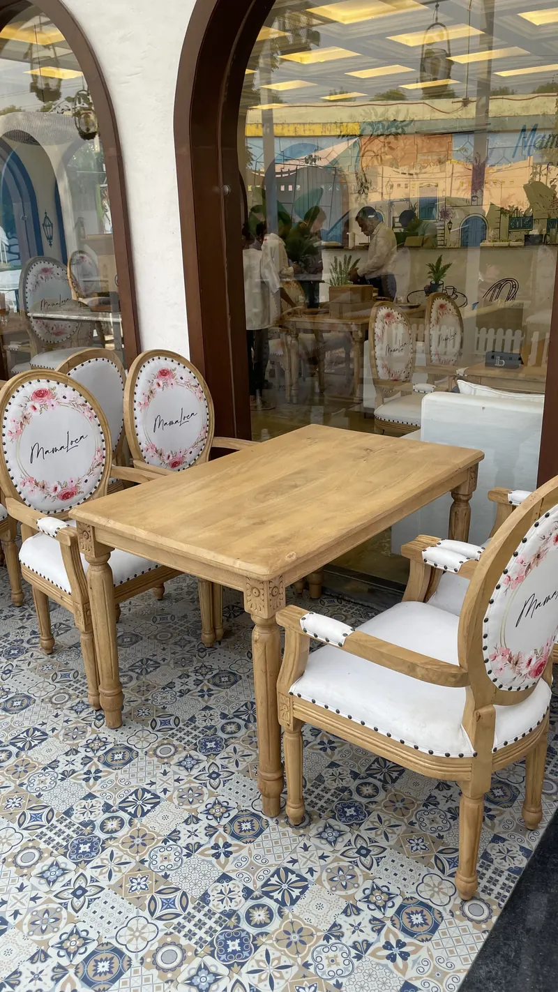 A pergola table on blue and white patterned tile, looking into the hall
