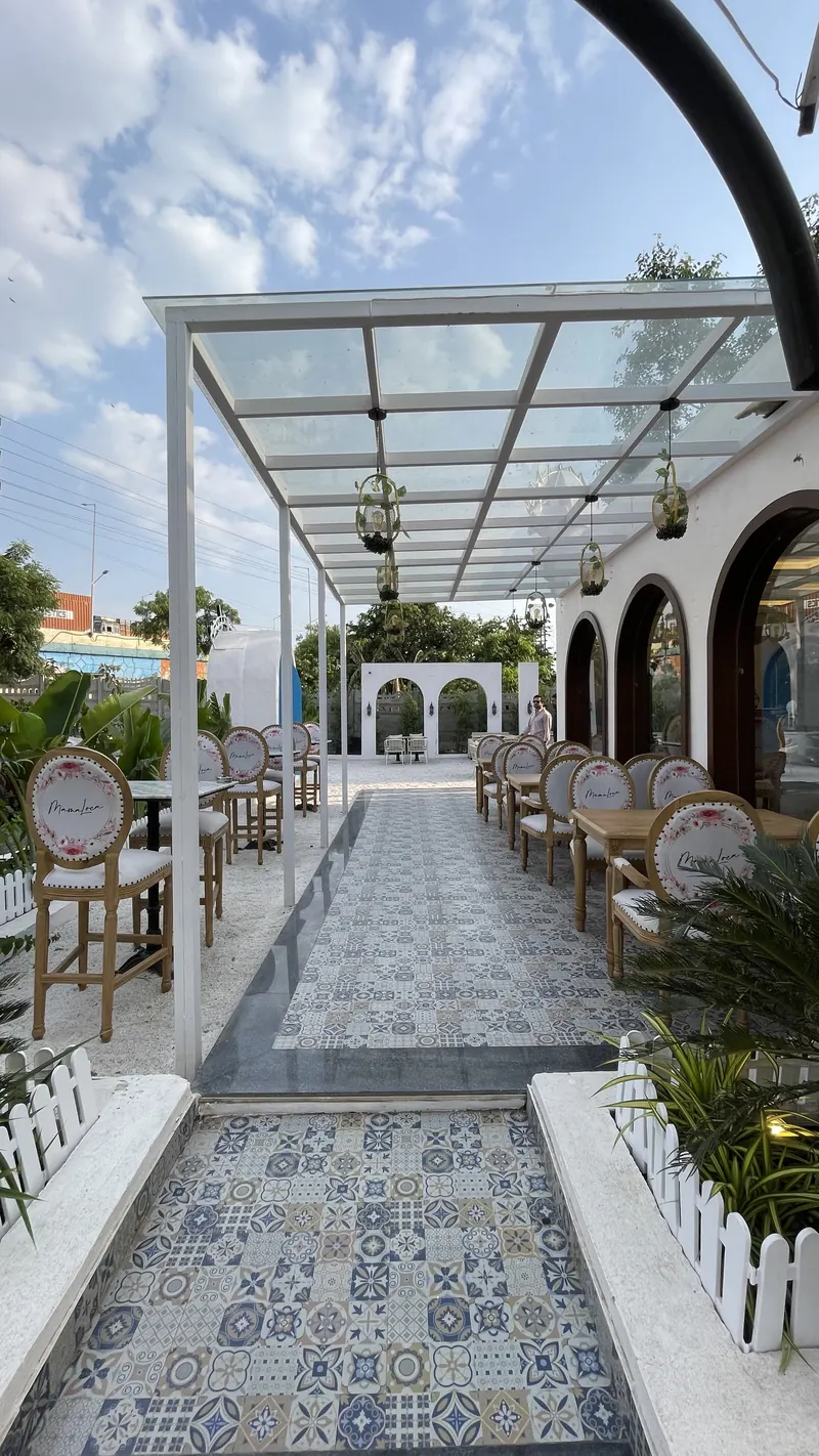 The tiled walkway down the pergola, open sky above the glass roof