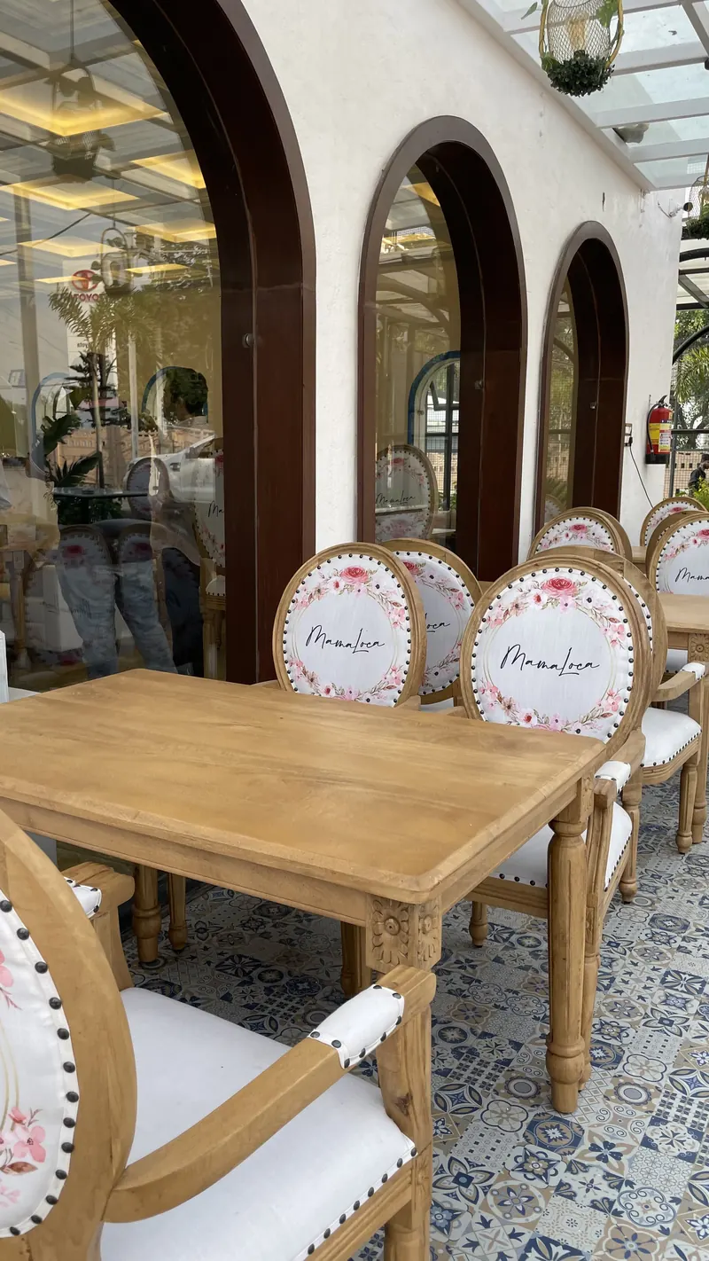A long wooden table under the glass pergola