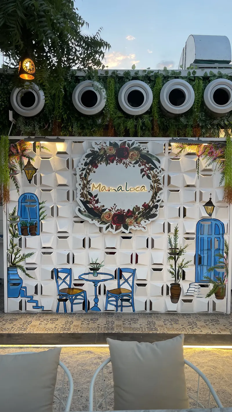 The garden wall, painted with blue doors, cafe chairs and a floral wreath