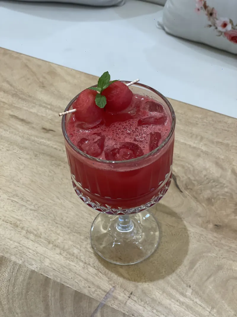 A red cooler in a cut-glass coupe, with melon and mint